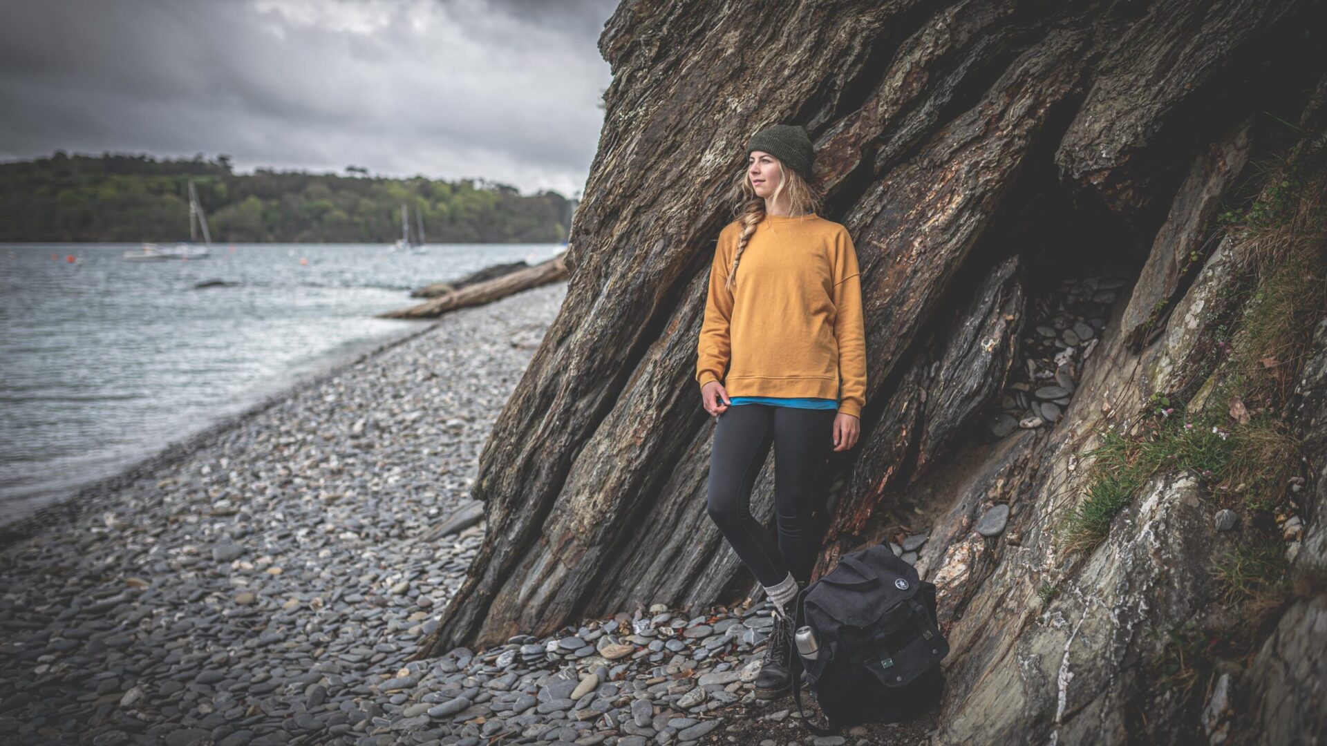 Young woman in hiking gear on a beach. Photo by professional business photographer Claire Wilson.
